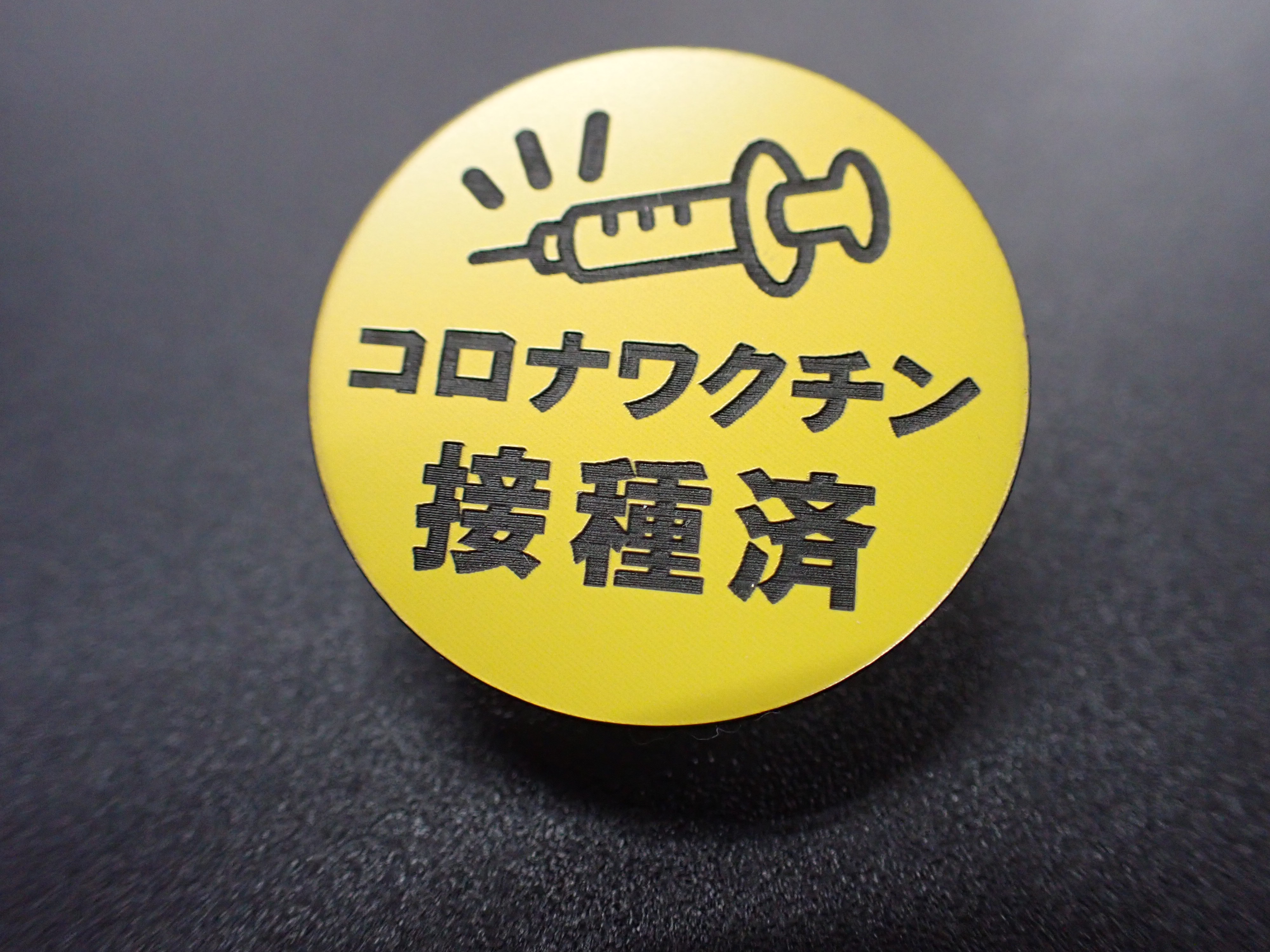 コロナワクチン接種済の社員はバッチをつけています。